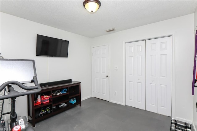 interior space with visible vents, a textured ceiling, and baseboards