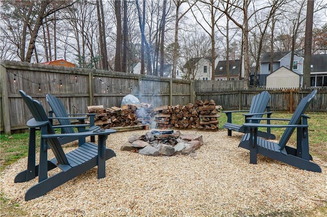 view of yard with a residential view, a fenced backyard, and an outdoor fire pit