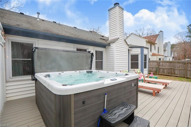 deck featuring fence and a hot tub