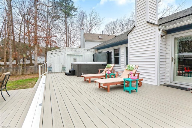 wooden deck with a hot tub and fence