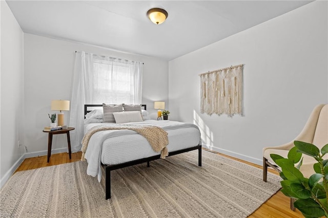 bedroom with baseboards and wood finished floors