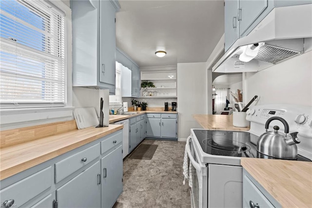 kitchen featuring under cabinet range hood, white appliances, butcher block counters, and open shelves