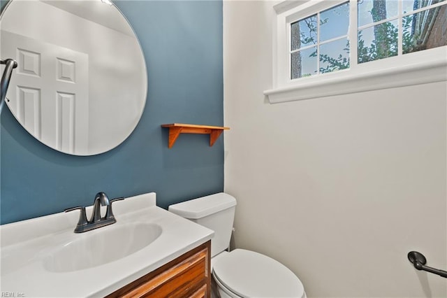 half bathroom with vanity and toilet