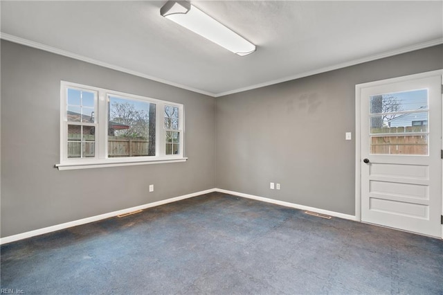 carpeted spare room with visible vents, baseboards, and crown molding