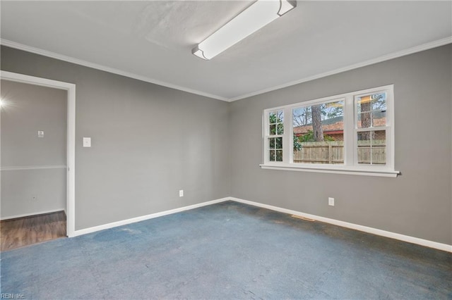 empty room featuring crown molding, carpet, baseboards, and visible vents