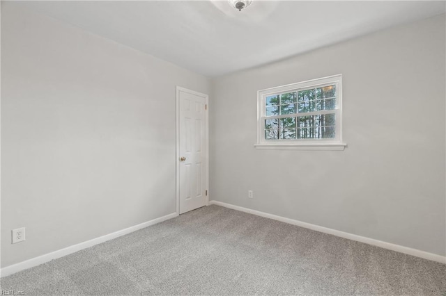 carpeted spare room featuring baseboards