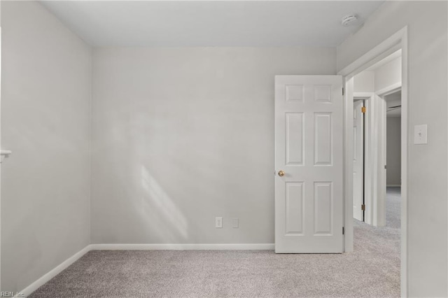 unfurnished room with carpet flooring and baseboards