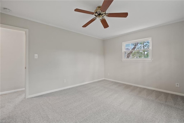 empty room featuring crown molding, a ceiling fan, baseboards, and carpet floors