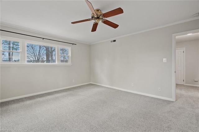 carpeted spare room featuring visible vents, a ceiling fan, crown molding, and baseboards