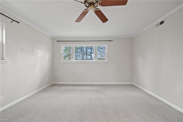 carpeted spare room with crown molding, baseboards, visible vents, and ceiling fan