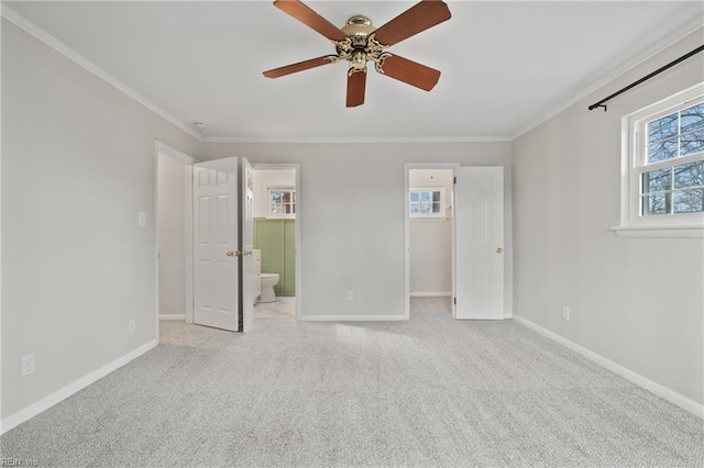 carpeted spare room with ceiling fan, baseboards, and ornamental molding