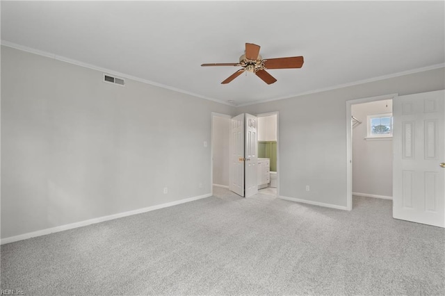 interior space with a walk in closet, crown molding, baseboards, and visible vents