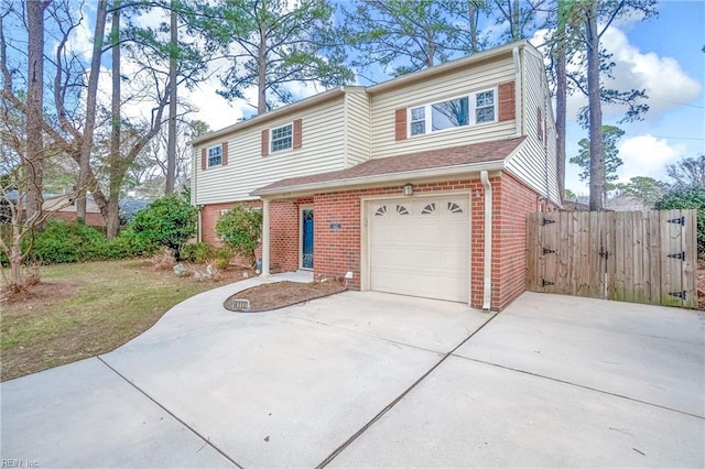 multi unit property with a garage, fence, and brick siding