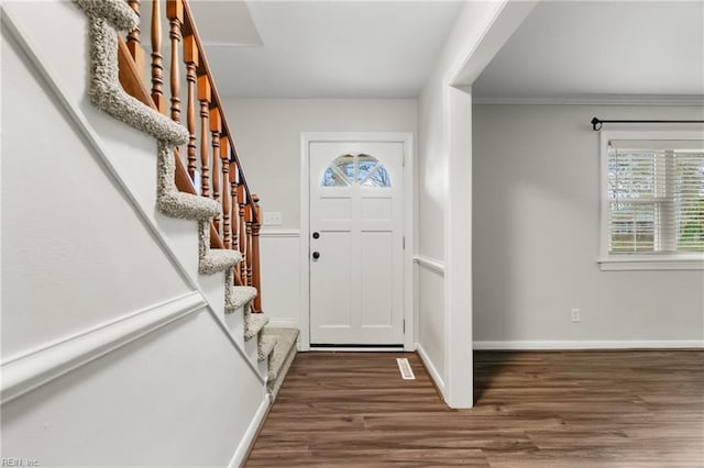 entrance foyer with baseboards, wood finished floors, and stairs