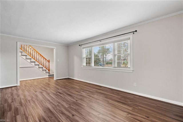 empty room with crown molding, stairway, wood finished floors, and baseboards