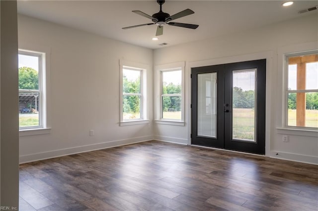 spare room featuring dark wood-type flooring, french doors, visible vents, and a healthy amount of sunlight