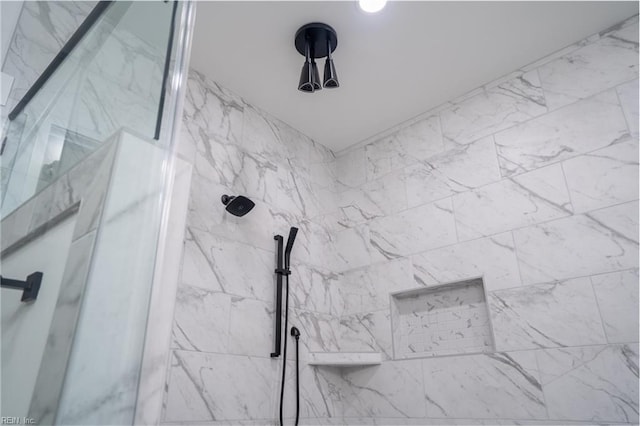 interior details featuring a marble finish shower