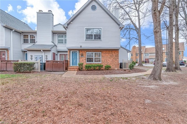 townhome / multi-family property featuring brick siding, cooling unit, a chimney, and fence