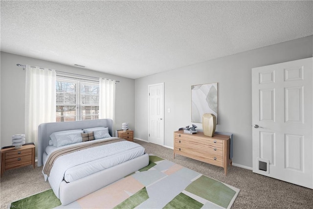 bedroom featuring baseboards, carpet floors, and a textured ceiling