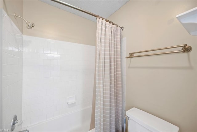 bathroom with shower / bath combo with shower curtain, toilet, and a textured ceiling