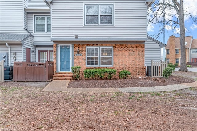 view of front of house with brick siding and central AC