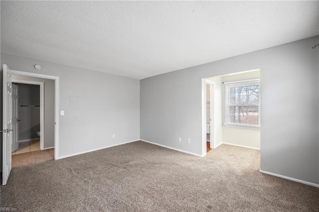 unfurnished bedroom featuring baseboards, carpet floors, and a textured ceiling