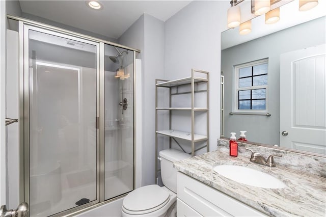 bathroom with toilet, a stall shower, and vanity