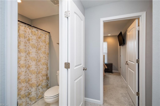 full bathroom featuring a shower with shower curtain, visible vents, baseboards, and toilet