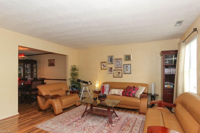 living area featuring visible vents and wood finished floors