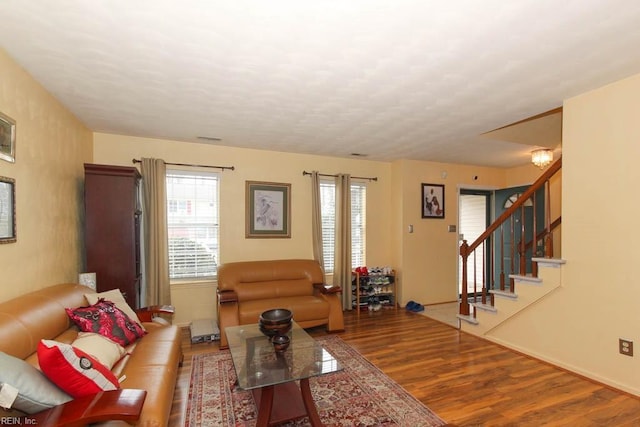 living room with visible vents, wood finished floors, and stairs