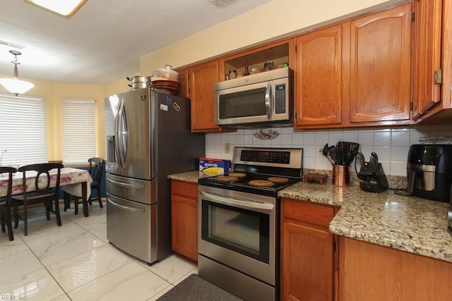 kitchen featuring decorative backsplash, brown cabinets, marble finish floor, and appliances with stainless steel finishes