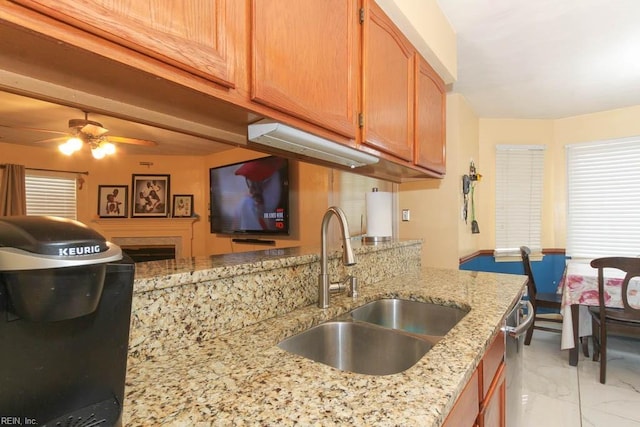 kitchen featuring marble finish floor, a sink, light stone counters, stainless steel dishwasher, and ceiling fan