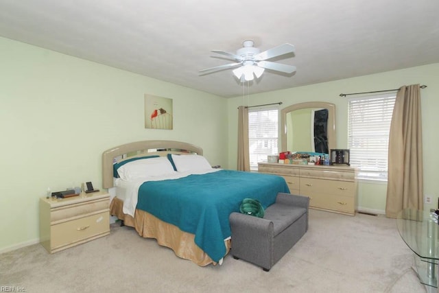 bedroom featuring baseboards, multiple windows, and light colored carpet