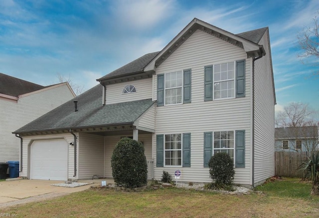 traditional-style home with a shingled roof, fence, a front yard, driveway, and an attached garage