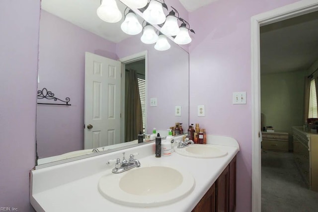 full bath with a sink, a notable chandelier, and double vanity