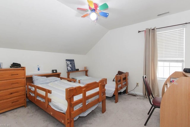 bedroom with a ceiling fan, vaulted ceiling, light colored carpet, and visible vents