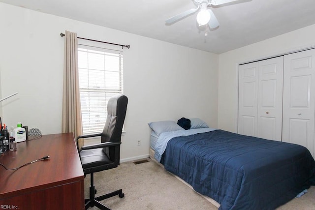 carpeted bedroom featuring a closet, baseboards, and ceiling fan