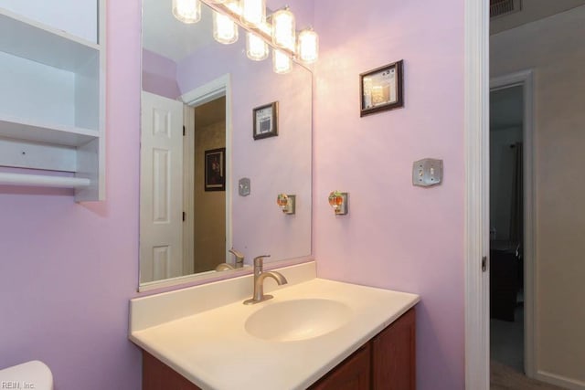 bathroom featuring vanity, toilet, and visible vents