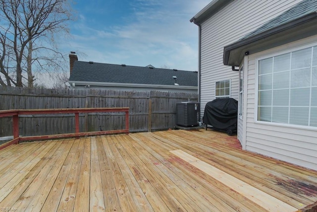 wooden deck featuring central AC unit, a grill, and fence