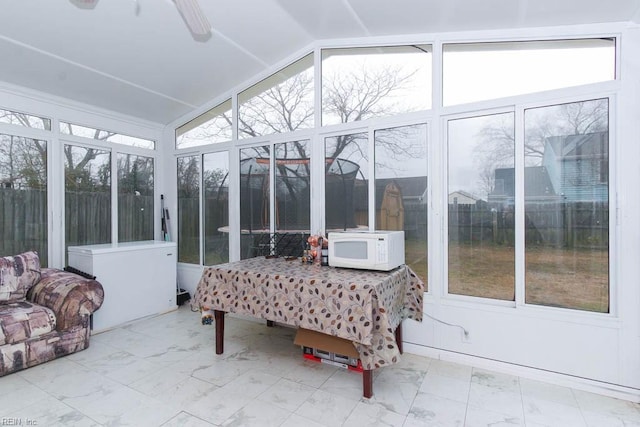 sunroom / solarium featuring ceiling fan and vaulted ceiling