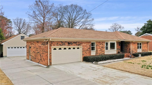 ranch-style house with brick siding, an attached garage, concrete driveway, and roof with shingles