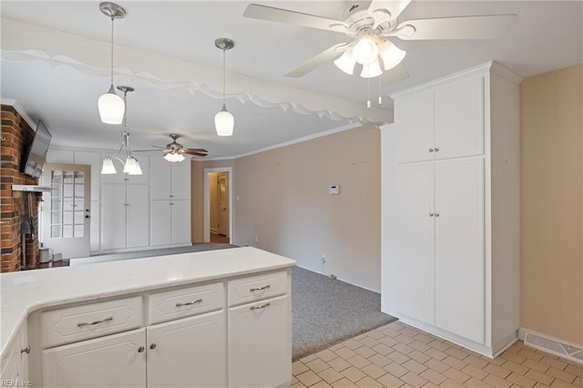 kitchen with white cabinetry, light countertops, hanging light fixtures, and a ceiling fan