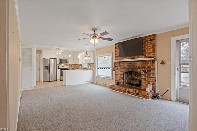 unfurnished living room with a fireplace, crown molding, light colored carpet, and ceiling fan