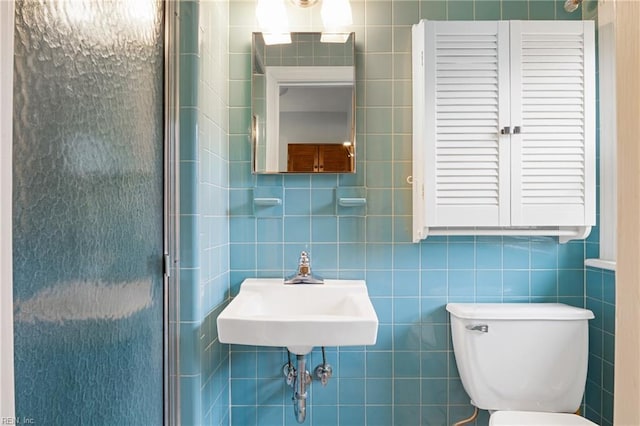 full bath with a shower stall, toilet, tile walls, and a sink