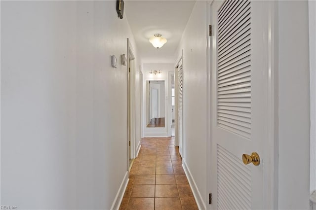 hall with tile patterned floors and baseboards