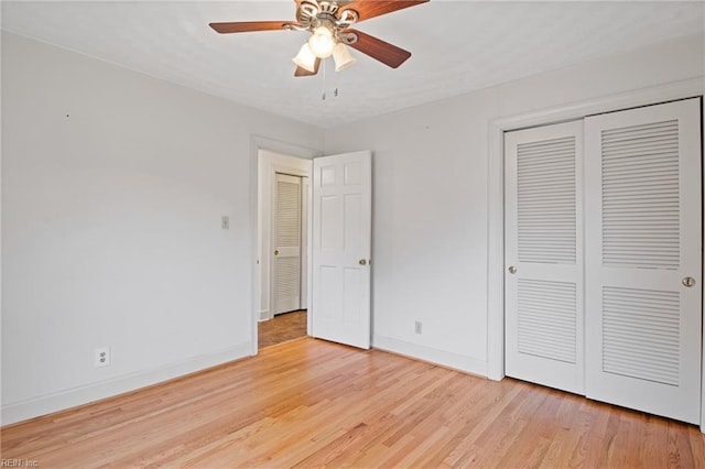 unfurnished bedroom featuring a closet, a ceiling fan, baseboards, and light wood finished floors