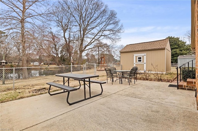 view of patio featuring an outdoor structure, outdoor dining area, and a fenced backyard