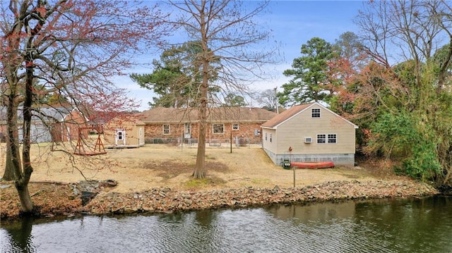 back of property with fence and a water view