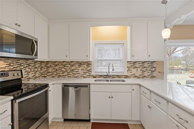 kitchen with a sink, plenty of natural light, tasteful backsplash, appliances with stainless steel finishes, and white cabinets