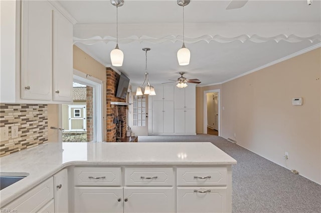 kitchen with ornamental molding, a ceiling fan, white cabinets, carpet flooring, and decorative backsplash